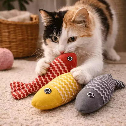 Jeu poisson pour chat avec une isabelle en train de jouer avec plusieurs poissons colorés, rouge, jaune et gris en intérieur